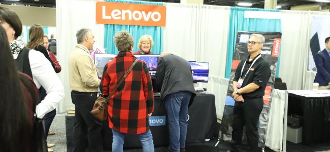 tradeshow attendees standing around the Lenovo booth